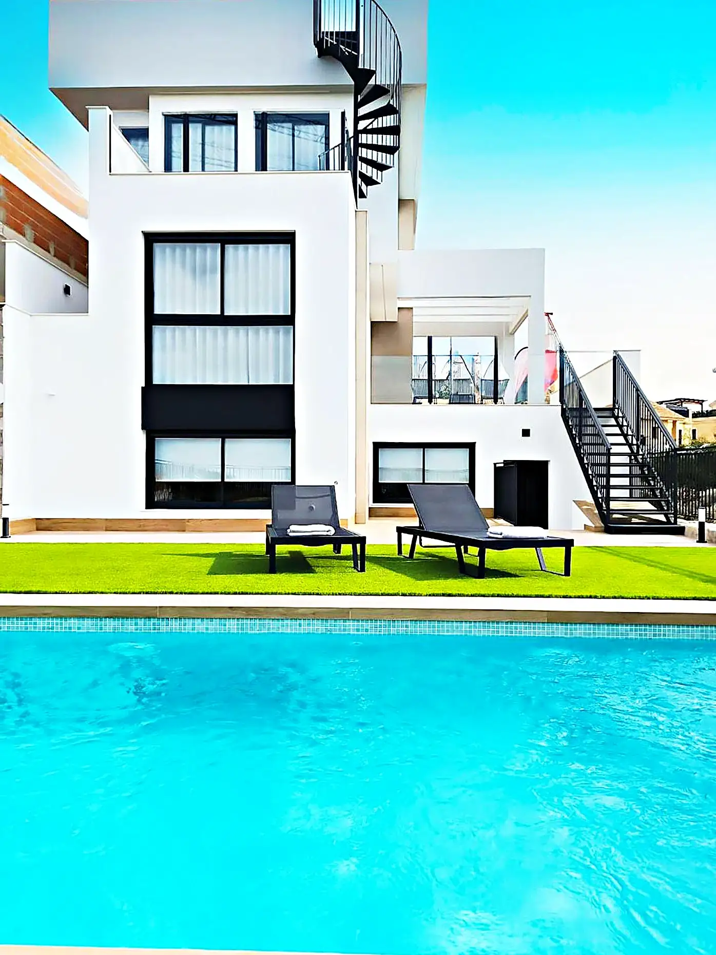 Piscina exterior de diseño con escalera de caracol en una villa de Sant Cugat