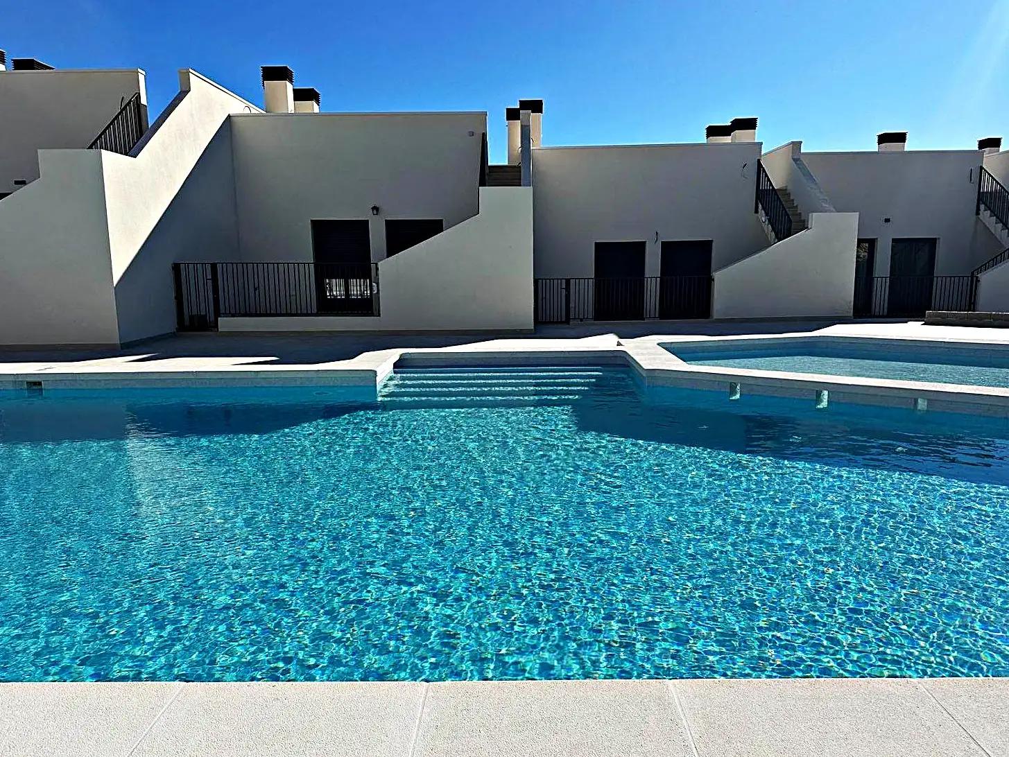 Piscina de obra nueva con lámina de agua turquesa en Vilanova i la Geltrú